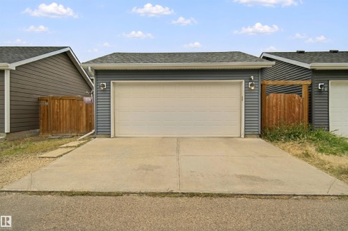 Detached garage with horizontal siding, a segmented garage door, and concrete driveway - 7603 Summerside Grande Boulevard Sw, Edmonton, AB - Outdoor With Exterior