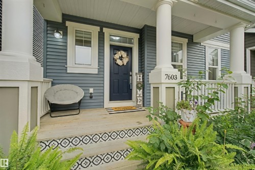 Covered porch with decorative tiled stair risers, classic white columns, and blue horizontal siding - 7603 Summerside Grande Boulevard Sw, Edmonton, AB - Outdoor