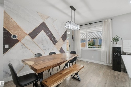 Accent wall with geometric marble-look paneling - 7603 Summerside Grande Boulevard Sw, Edmonton, AB - Indoor Photo Showing Dining Room