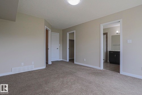 Neutral-toned walls complement plush carpeting throughout - #13 5873 Mullen Pl Nw, Edmonton, AB - Indoor Photo Showing Other Room