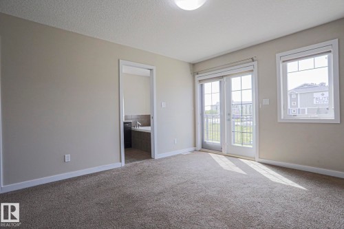 Carpeted room with neutral wall tones, white trim, and a ceiling light fixture - #13 5873 Mullen Pl Nw, Edmonton, AB - Indoor Photo Showing Other Room