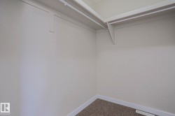 Built-in shelving with hanging rods and carpet flooring - 