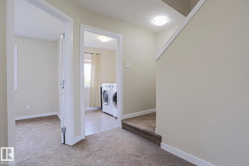 Bright upper-level hallway with neutral wall finishes, recessed ceiling lighting, and carpet flooring - #13 5873 Mullen Pl Nw, Edmonton, AB - Indoor