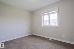 Beige interior walls with a single window featuring white trim and roller shades - 