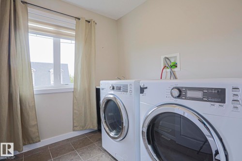 Laundry room with tiled flooring and a window - #13 5873 Mullen Pl Nw, Edmonton, AB - Indoor Photo Showing Laundry Room
