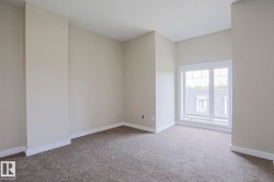 Bright corner room featuring neutral wall finishes, neutral carpet flooring, and dual windows with natural light - 