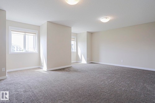 Carpeted flooring, neutral wall tones, multiple windows, recessed lighting - #13 5873 Mullen Pl Nw, Edmonton, AB - Indoor Photo Showing Other Room
