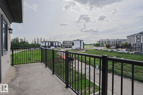 Concrete balcony with black metal railings - #13 5873 Mullen Pl Nw, Edmonton, AB - Outdoor With Balcony With Exterior