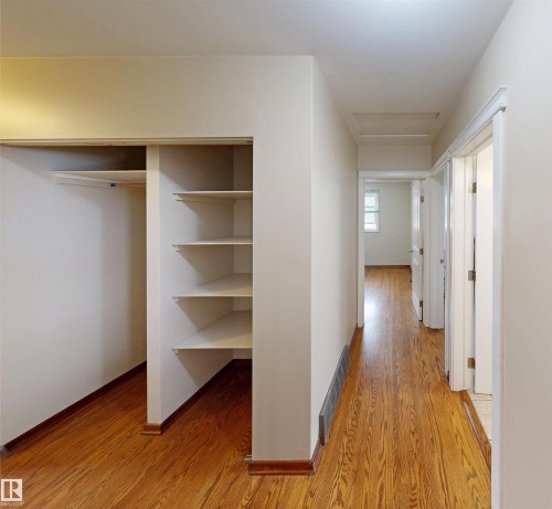 Hallway featuring wood-finish flooring, white walls, and white trim - 9531 74 Street Nw, Edmonton, AB - Indoor