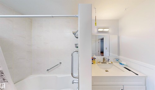 White bathroom vanity with an integrated sink and chrome faucet - 9531 74 Street Nw, Edmonton, AB - Indoor Photo Showing Bathroom