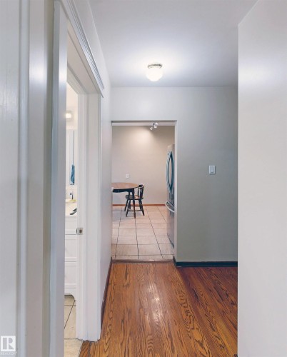 Wood-finish flooring leading to a tiled area - 9531 74 Street Nw, Edmonton, AB - Indoor Photo Showing Other Room