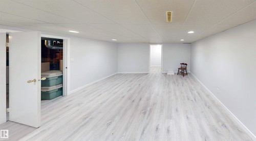 Spacious room featuring wood-finish flooring, white walls, and recessed lighting - 9531 74 Street Nw, Edmonton, AB - Indoor