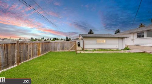 Expansive lawn area with wood perimeter fencing and a single-story detached garage - 9531 74 Street Nw, Edmonton, AB - Outdoor