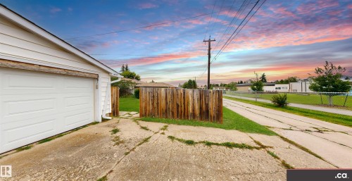 Detached garage with white siding, concrete driveway, and wood fencing - 9531 74 Street Nw, Edmonton, AB - Outdoor