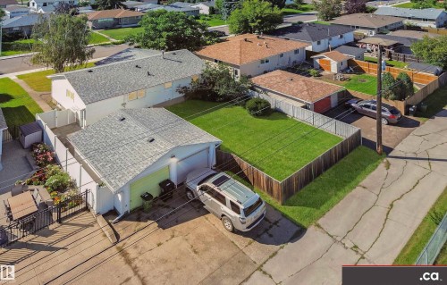 Detached garage with a light green garage door, concrete driveway, fenced yard, and an additional storage shed - 9531 74 Street Nw, Edmonton, AB - Outdoor With Deck Patio Veranda