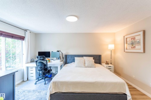 Spacious room featuring a large window, neutral wall tones, overhead lighting, and light-toned flooring - 8527 Ellis Link Nw, Edmonton, AB - Indoor Photo Showing Bedroom