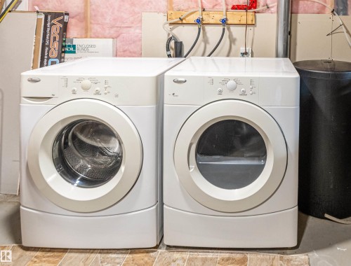 White front-loading washing machine and dryer unit - 8527 Ellis Link Nw, Edmonton, AB - Indoor Photo Showing Laundry Room