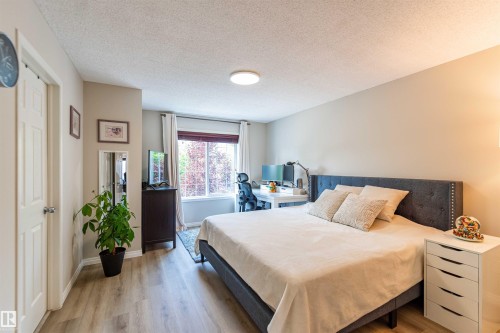 Spacious room featuring wood-finish flooring, a window offering natural light, and neutral wall tones - 8527 Ellis Link Nw, Edmonton, AB - Indoor Photo Showing Bedroom