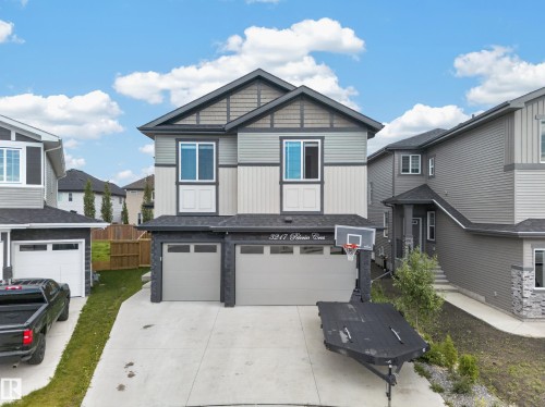 Two-story home with a multi-textured facade, featuring two garage doors, and a concrete driveway - 3217 Pelerin Crescent, Beaumont, AB - Outdoor With Facade