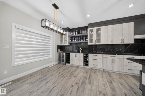 Wood-finish flooring with a linear chandelier - 3217 Pelerin Crescent, Beaumont, AB - Indoor Photo Showing Kitchen