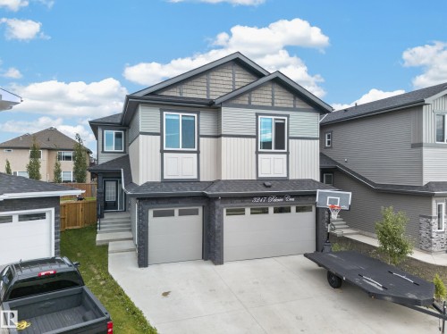 Contemporary exterior with mixed siding, stone accents, and a dual garage - 3217 Pelerin Crescent, Beaumont, AB - Outdoor With Facade