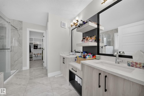 Dual vanity with integrated sinks, quartz countertops, and matte black hardware - 3217 Pelerin Crescent, Beaumont, AB - Indoor Photo Showing Bathroom