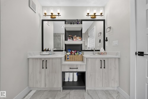 Dual vanities with integrated sinks, light-toned cabinetry, and coordinating countertops - 3217 Pelerin Crescent, Beaumont, AB - Indoor