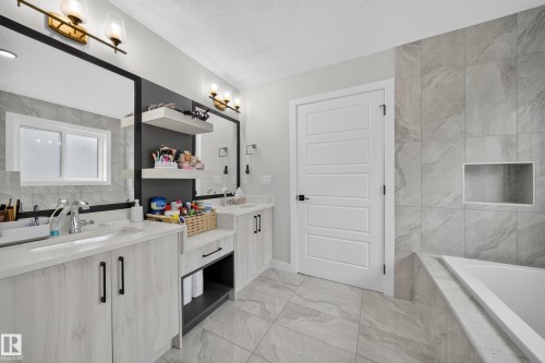 Dual vanity with undermount sinks, panel door cabinetry, and integrated shelving - 3217 Pelerin Crescent, Beaumont, AB - Indoor Photo Showing Bathroom