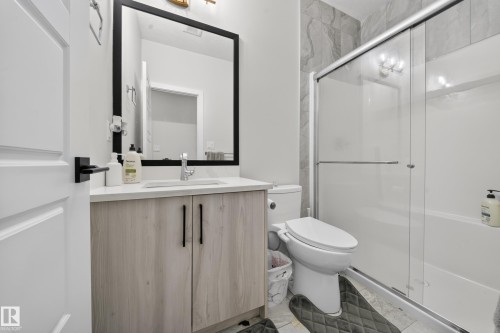 Vanity with light wood-finish cabinetry, white countertop, and integrated sink - 3217 Pelerin Crescent, Beaumont, AB - Indoor Photo Showing Bathroom