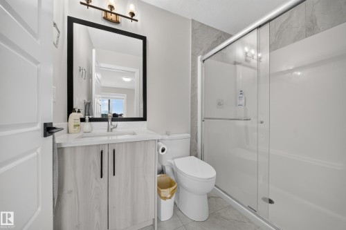 Vanity with wood-finish cabinetry, white countertop, and rectangular sink - 3217 Pelerin Crescent, Beaumont, AB - Indoor Photo Showing Bathroom