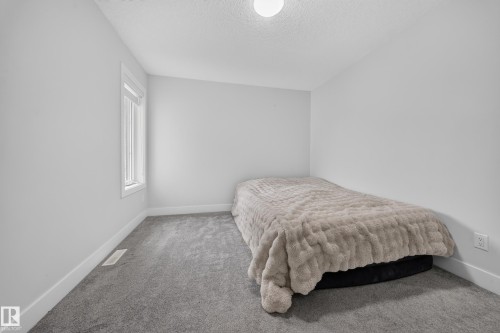 Neutral wall paint, plush carpet flooring, and a single window with white trim - 3217 Pelerin Crescent, Beaumont, AB - Indoor Photo Showing Bedroom