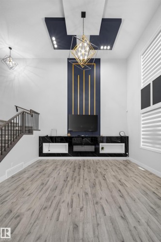 Wood-finish flooring, accent ceiling lighting, and a built-in media console with storage - 3217 Pelerin Crescent, Beaumont, AB - Indoor