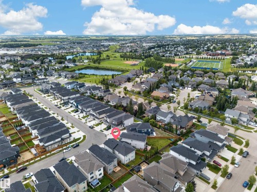 Aerial view of the surrounding residential area featuring a curvilinear street layout, multiple detached homes, and bodies of water - 3217 Pelerin Crescent, Beaumont, AB - Outdoor With View