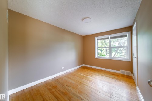 Hardwood flooring, painted walls, window with natural light, white trim, and a flush mount ceiling light - 115 Griesbach Road Nw, Edmonton, AB - Indoor Photo Showing Other Room