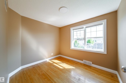 Hardwood flooring, neutral wall tones, white trim, and a double window - 115 Griesbach Road Nw, Edmonton, AB - Indoor Photo Showing Other Room