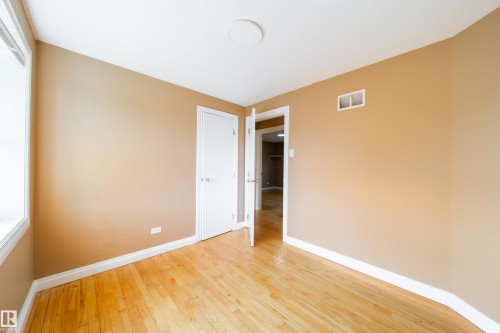 Wood-finish flooring, white trim, and neutral wall paint - 115 Griesbach Road Nw, Edmonton, AB - Indoor Photo Showing Other Room