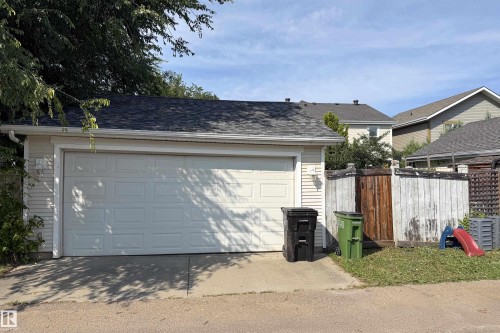 Detached garage with a paneled door, asphalt shingle roof, and exterior siding - 115 Griesbach Road Nw, Edmonton, AB - Outdoor