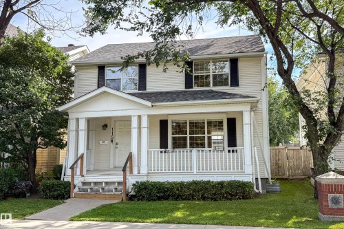 Two-story residence with a covered front porch and column supports, featuring a gabled roof and a well-maintained lawn - 115 Griesbach Road Nw, Edmonton, AB - Outdoor With Facade