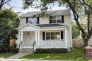 Two-story residence with a covered front porch and column supports, featuring a gabled roof and a well-maintained lawn - 115 Griesbach Road Nw, Edmonton, AB  - Outdoor With Facade 