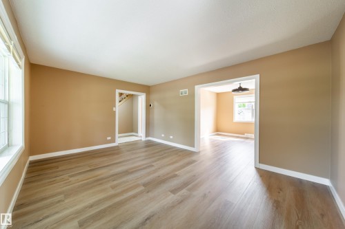 Spacious room with wood-finish flooring, neutral wall tones, and white trim - 115 Griesbach Road Nw, Edmonton, AB - Indoor Photo Showing Other Room
