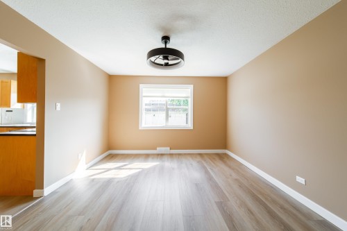 Light wood-finish flooring with a white trim - 115 Griesbach Road Nw, Edmonton, AB - Indoor Photo Showing Other Room