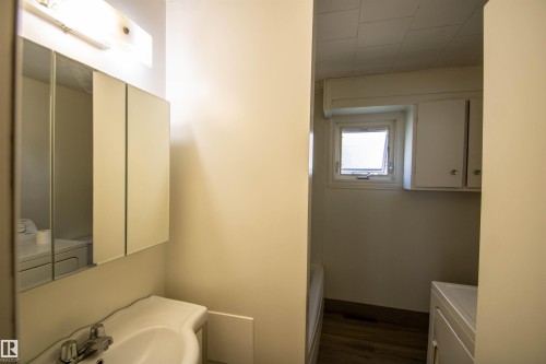 Pedestal sink with chrome faucet, mirrored medicine cabinet, and overhead light fixture - 4706 51 Ave, St. Paul Town, AB - Indoor Photo Showing Bathroom