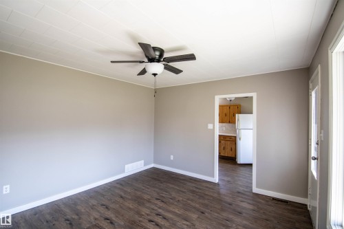 Wood-finish flooring with light neutral wall paint and white trim - 4706 51 Ave, St. Paul Town, AB - Indoor Photo Showing Other Room
