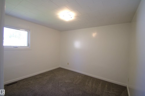Wall-to-wall carpeting and white walls with trim - 4706 51 Ave, St. Paul Town, AB - Indoor Photo Showing Other Room