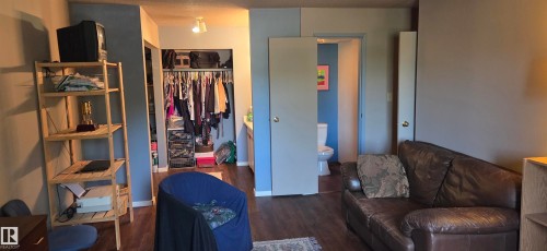 Wood-finish flooring throughout, light gray wall color, and a built-in closet with track lighting - #215 4404 122 St Nw, Edmonton, AB - Indoor