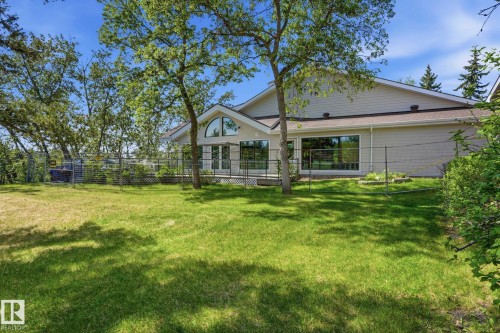 Expansive rear yard featuring mature trees and a manicured lawn - #215 4404 122 St Nw, Edmonton, AB - Outdoor With Deck Patio Veranda