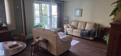 Wood-finish flooring throughout, complemented by light-colored walls and a sliding glass door with balcony access - 