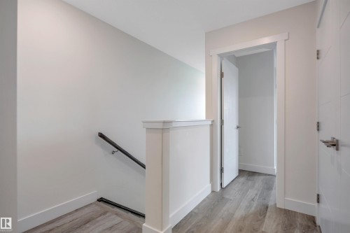 Light wood-finish flooring, white walls, and bright white trim - #4 9250 156 Av Nw, Edmonton, AB - Indoor Photo Showing Other Room