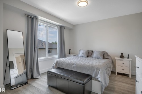 Recessed window with white trim, wood-finish flooring, flush mount ceiling light, and light gray walls - #4 9250 156 Av Nw, Edmonton, AB - Indoor Photo Showing Bedroom