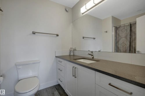 White shaker-style vanity with multiple drawers, gray countertop, undermount sink, and chrome faucet - #4 9250 156 Av Nw, Edmonton, AB - Indoor Photo Showing Bathroom